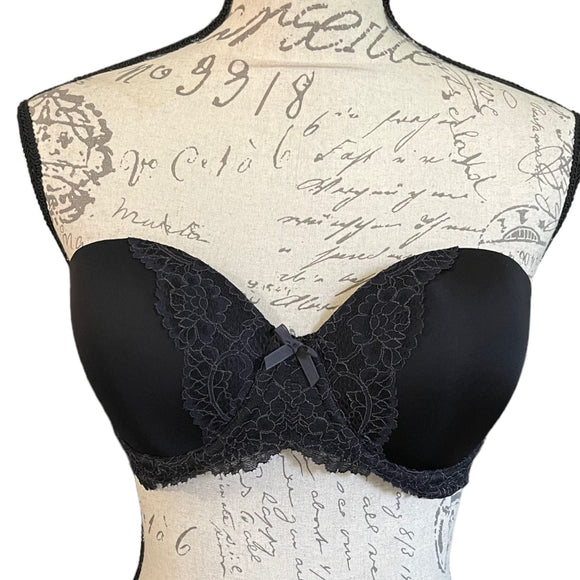 Front of Black lace bra on a mannequin with vintage-style text background