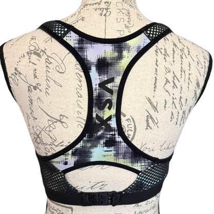 Sports bra with 'VSX' branding on a mannequin with a script background