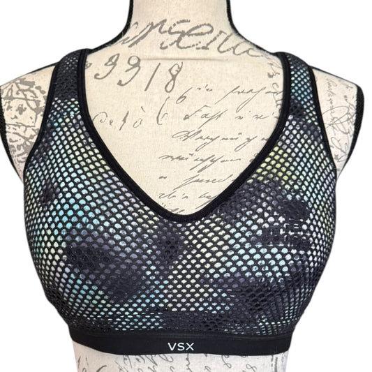 Front of Black mesh sports bra with 'VSX' branding on a mannequin with tattooed arm.