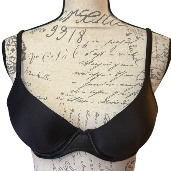 Black bra on a mannequin with a vintage script background