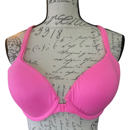 Bright pink molded underwire bra displayed on a vintage-style fabric dress form with cursive writing.
