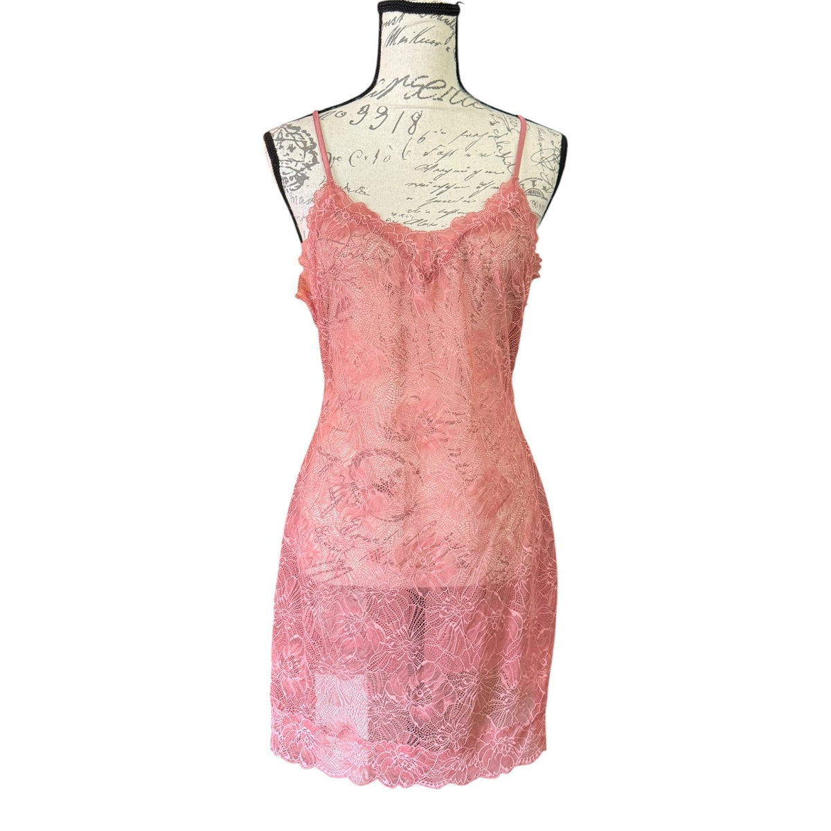 A pink lace slip dress lingerie displayed on a vintage-style dress form mannequin against a plain white background.