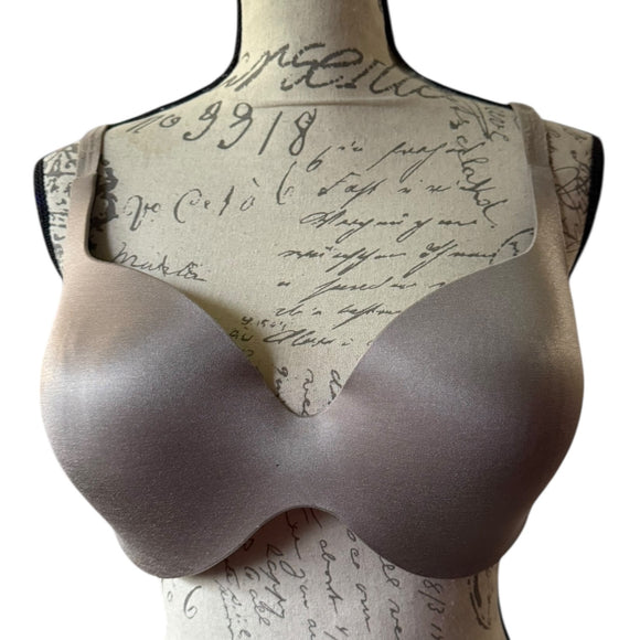 Front of Mannequin bust wearing a bra with a textured background