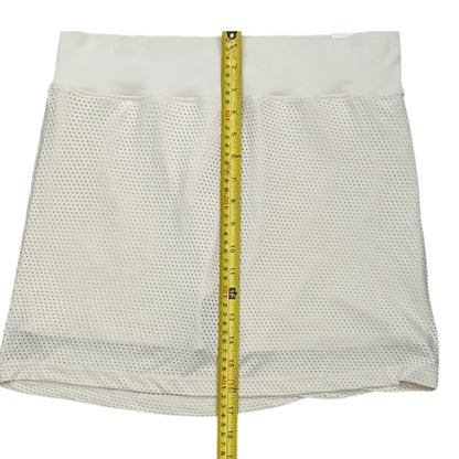Mesh skort shown flat on a white background with a yellow measuring tape running vertically down the center to indicate size.