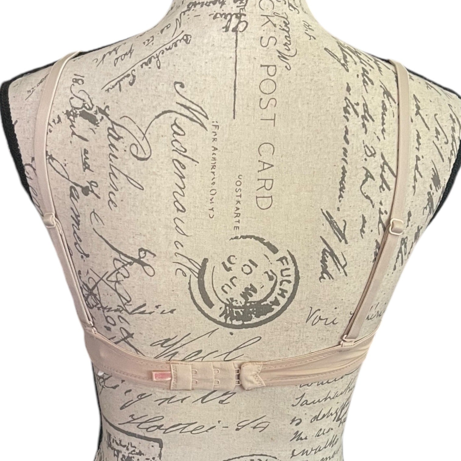 Back of beige bra with vintage postcard design on a mannequin