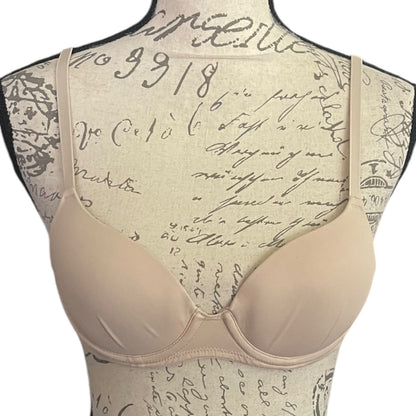 Beige bra on a mannequin with vintage script background