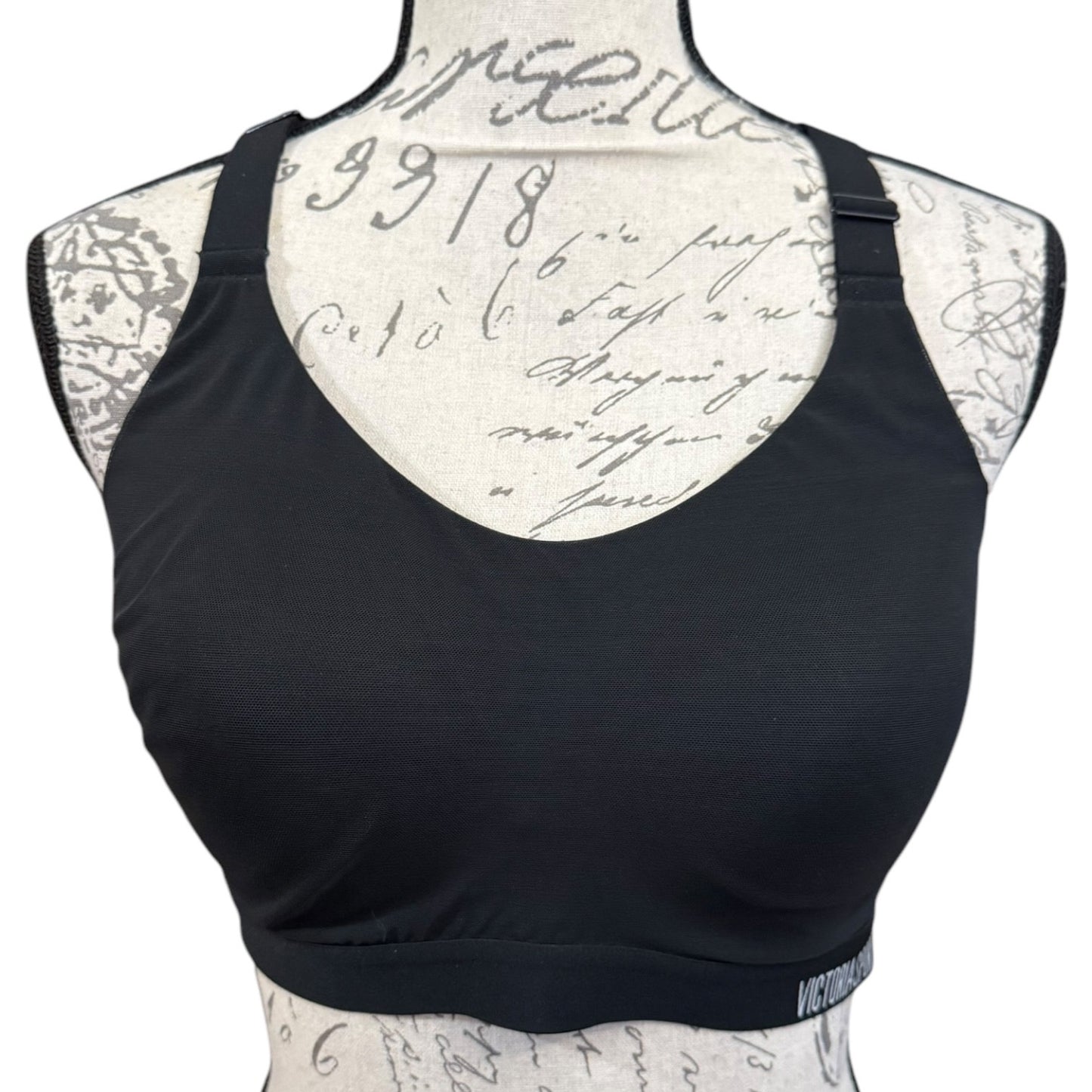 Black sports bra on a mannequin with a script patterned back