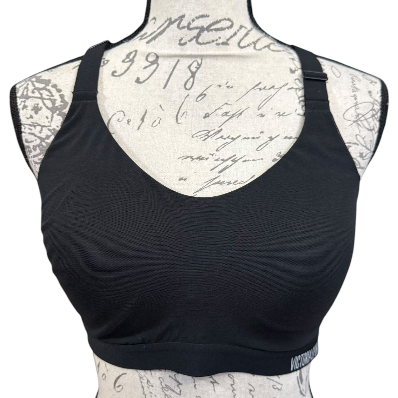 Black sports bra on a mannequin with a script patterned back