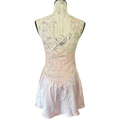 A sleeveless light pink babydoll displayed on a mannequin, shown from the back. 