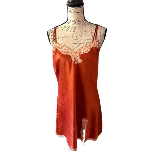 Orange satin slip dress with lace details on a mannequin against a white background