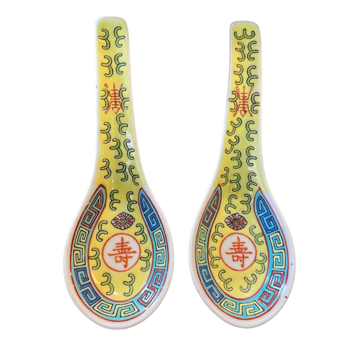Two decorative spoons with a yellow glaze, featuring hand-painted blue, green, red, and gold patterns and Chinese characters, set against a plain white background.