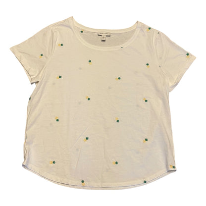 An white short-sleeve crop top with small pineapples embroidered  motifs scattered across the front, laid flat on a white background.