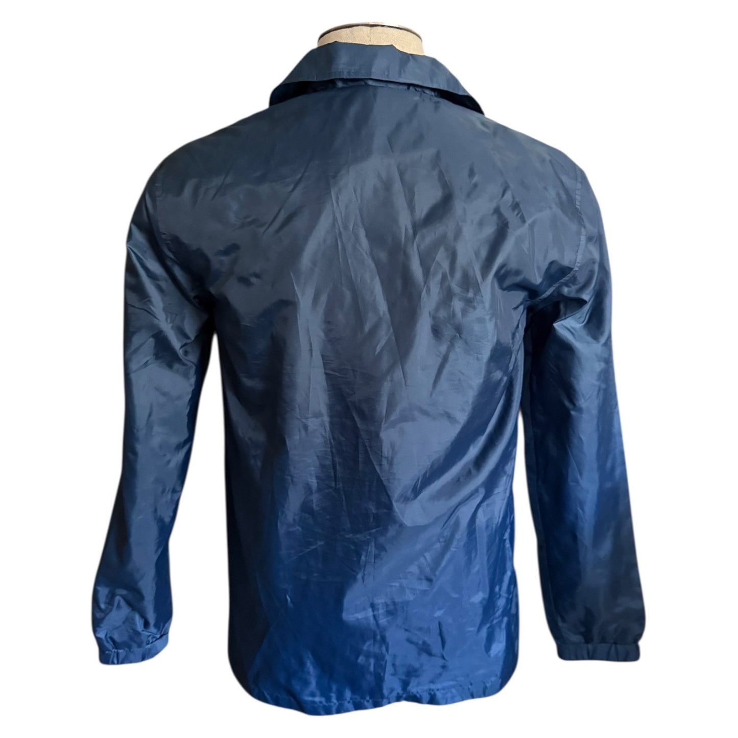 Back of blue jacket on a mannequin against a white background