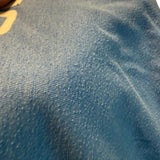Close-up of blue fabric with a visible pilling