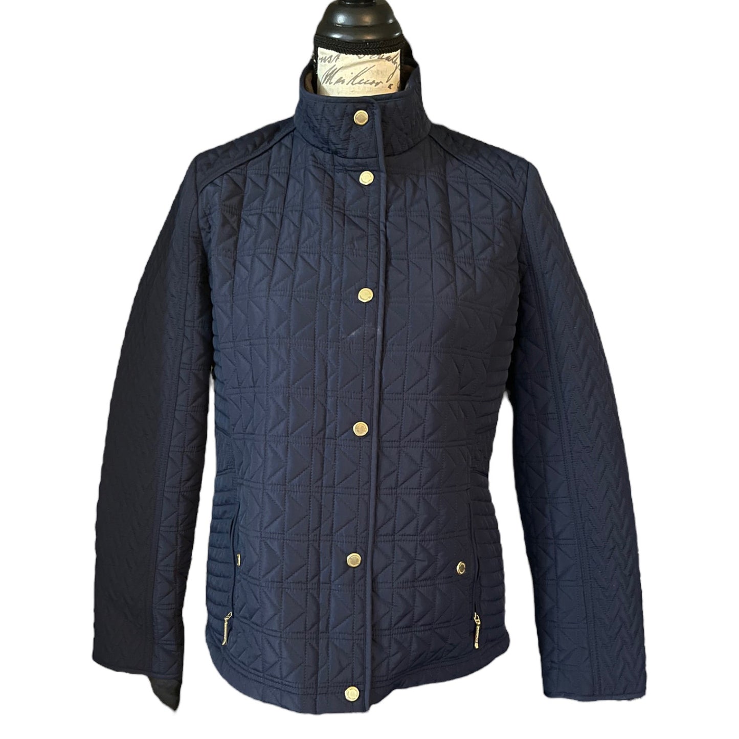 Front of Navy quilted jacket with  buttons on a white background