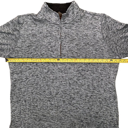 Gray sweater with a measuring tape for size reference on a white background