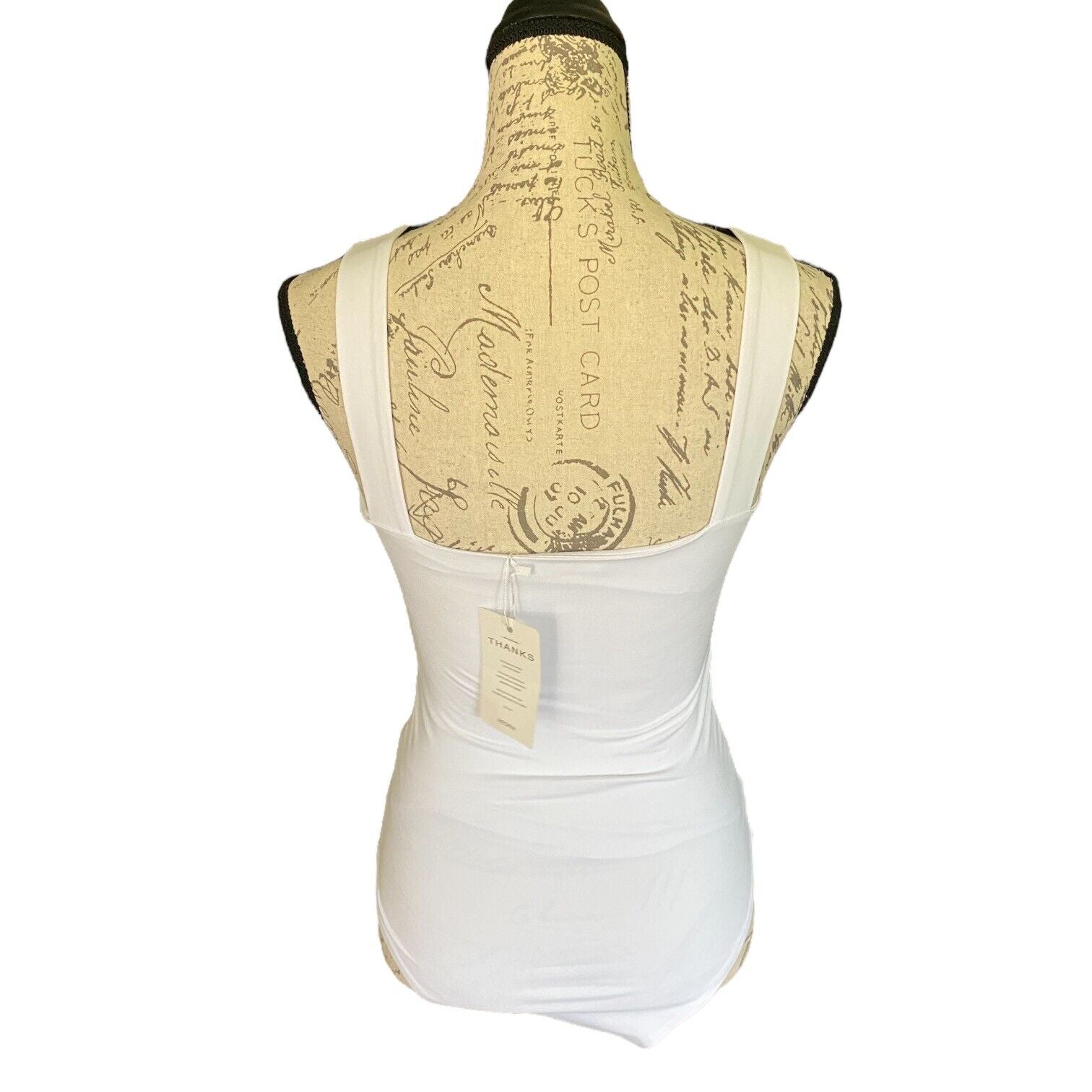 White bodysuit on a mannequin with a decorative back panel on a white background
