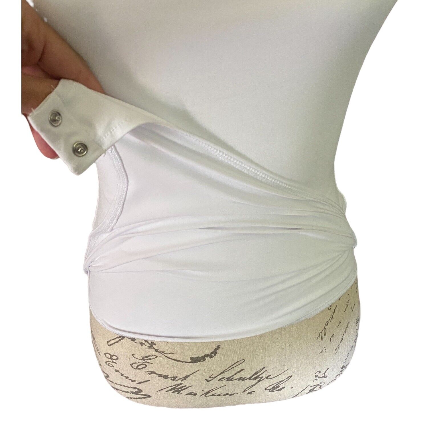 White top with layers featuring script text on a white background