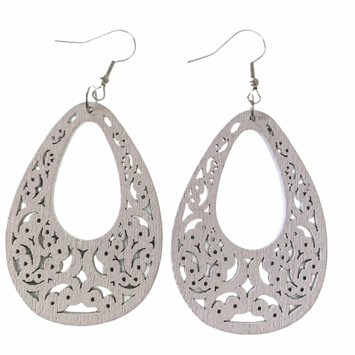 A pair of white teardrop-shaped dangle earrings with intricate filigree cutouts and fishhook wires, displayed against a solid white background.
