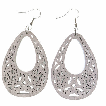 A pair of white teardrop-shaped dangle earrings with intricate filigree cutouts and fishhook wires, displayed against a solid white background.