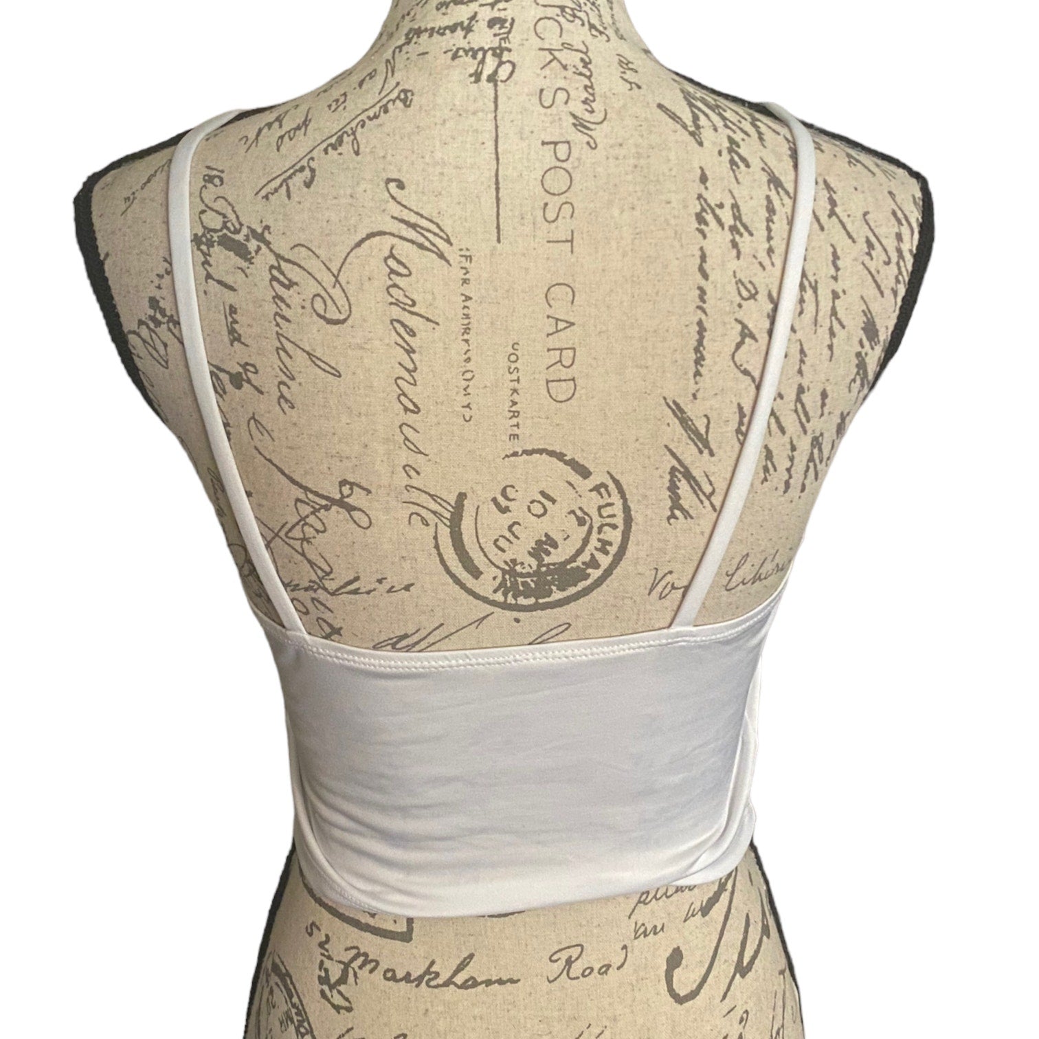 White tank bra back on a mannequin with vintage-style script design