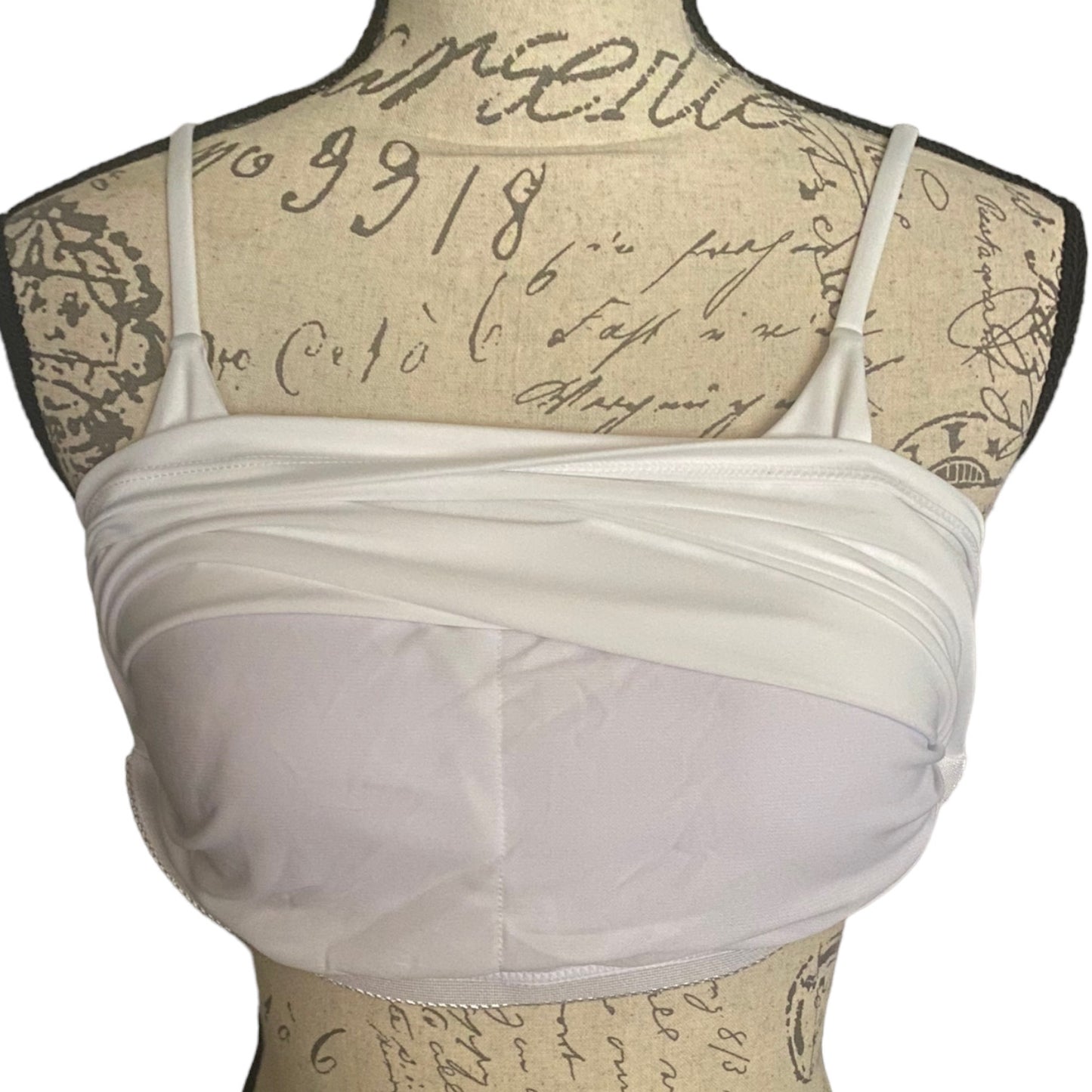White front of built in bra on a mannequin with an old document background