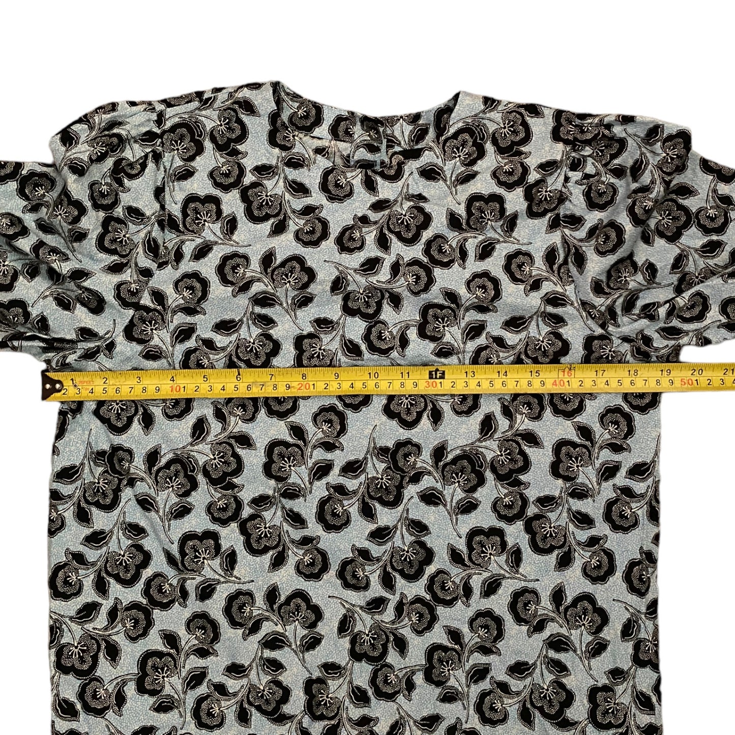 Floral patterned shirt with a measuring tape on a white background