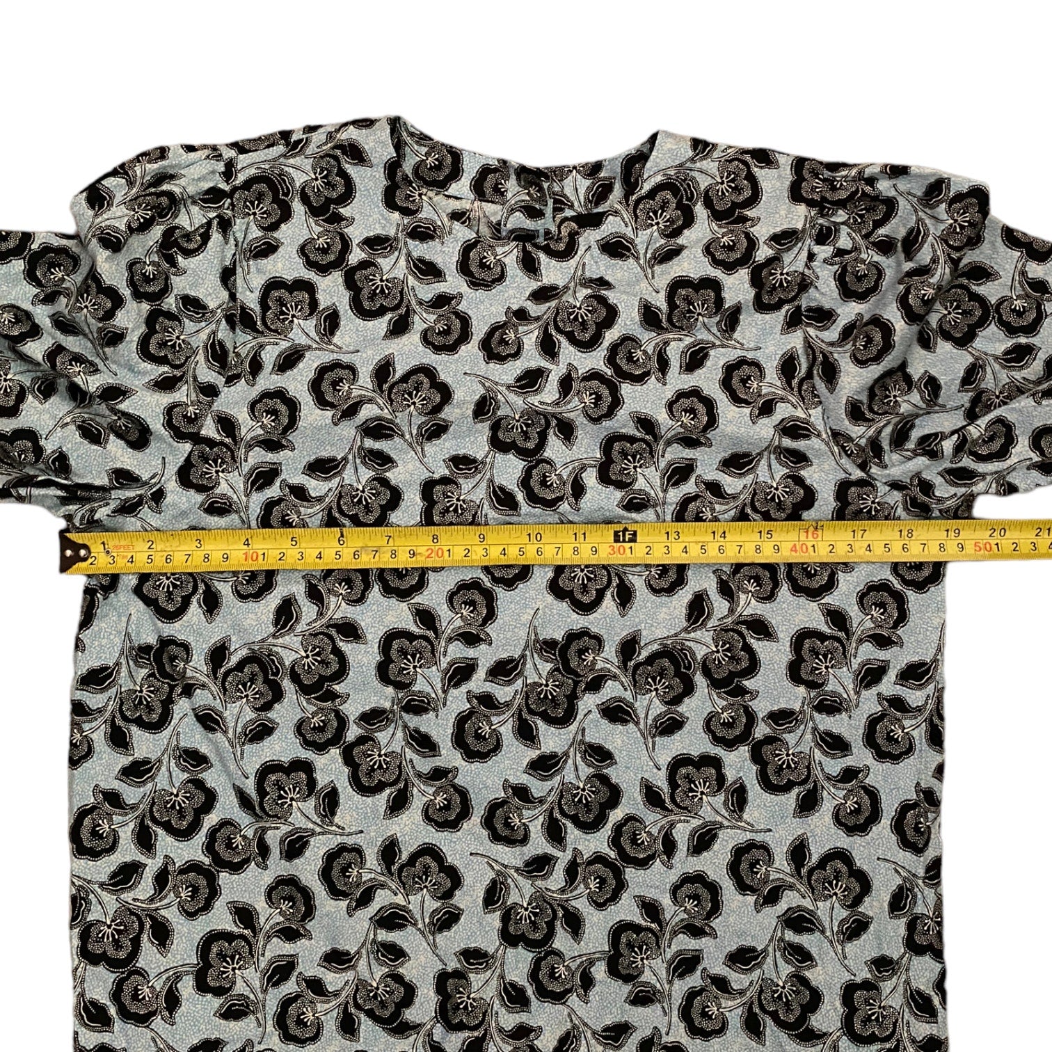 Floral patterned shirt with a measuring tape on a white background