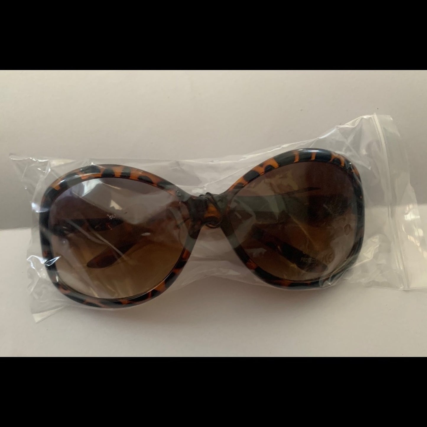 Sunglasses in clear plastic packaging on a white background