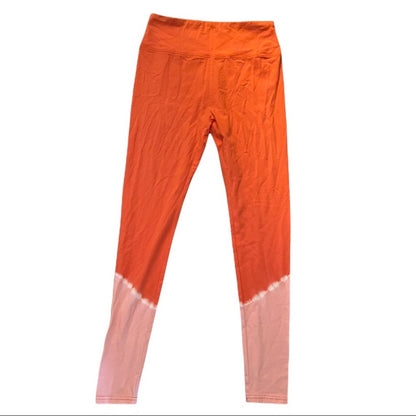 Orange leggings with a gradient to pink at the bottom on a white background