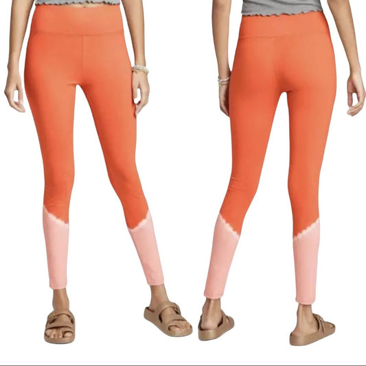 Orange and pink gradient leggings worn by a person on a white background