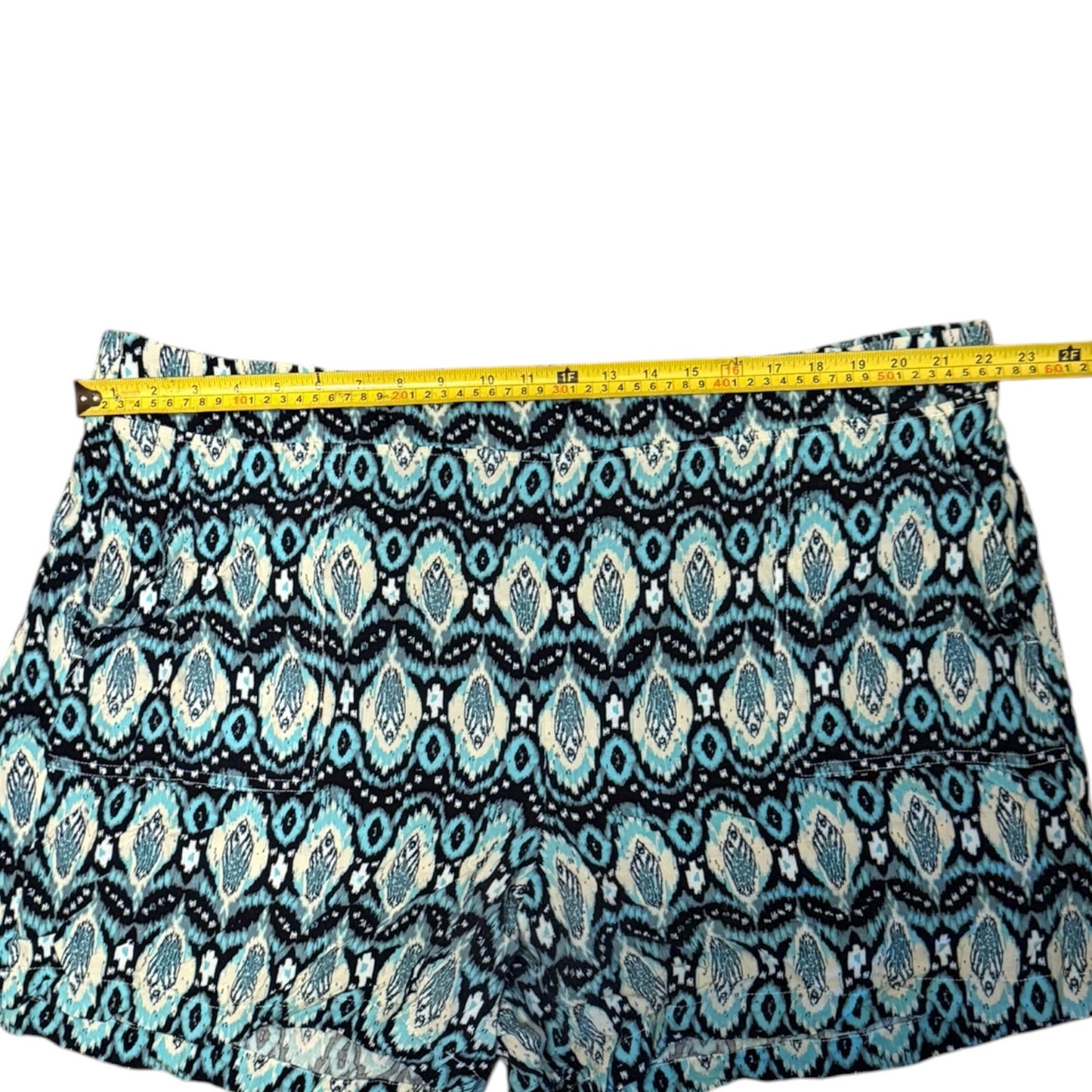 Patterned shorts with  geometric ikat design, shown with a yellow tape measure across the waistband to indicate size.