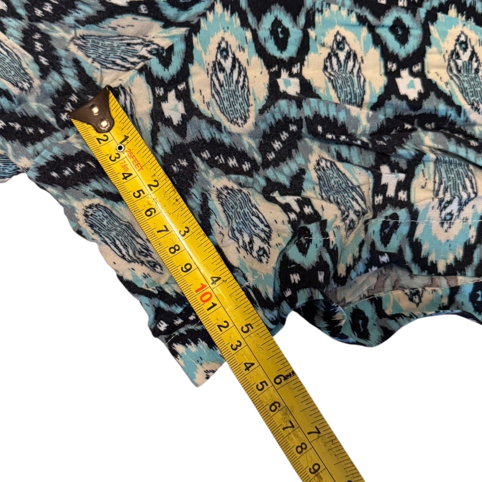 Inseam of shorts with a yellow measuring tape on a white background