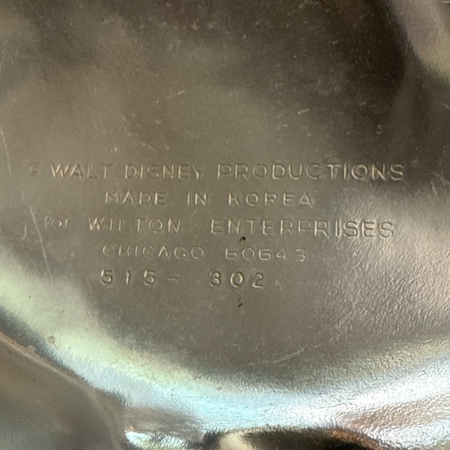 Metallic surface with engraved text indicating Walt Disney Productions and Wilton Enterprises.