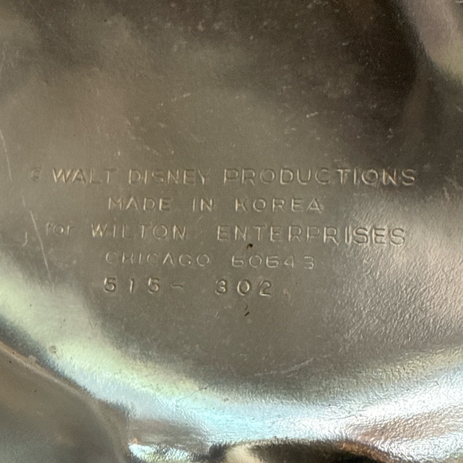 Metallic surface with engraved text indicating Walt Disney Productions and Wilton Enterprises.
