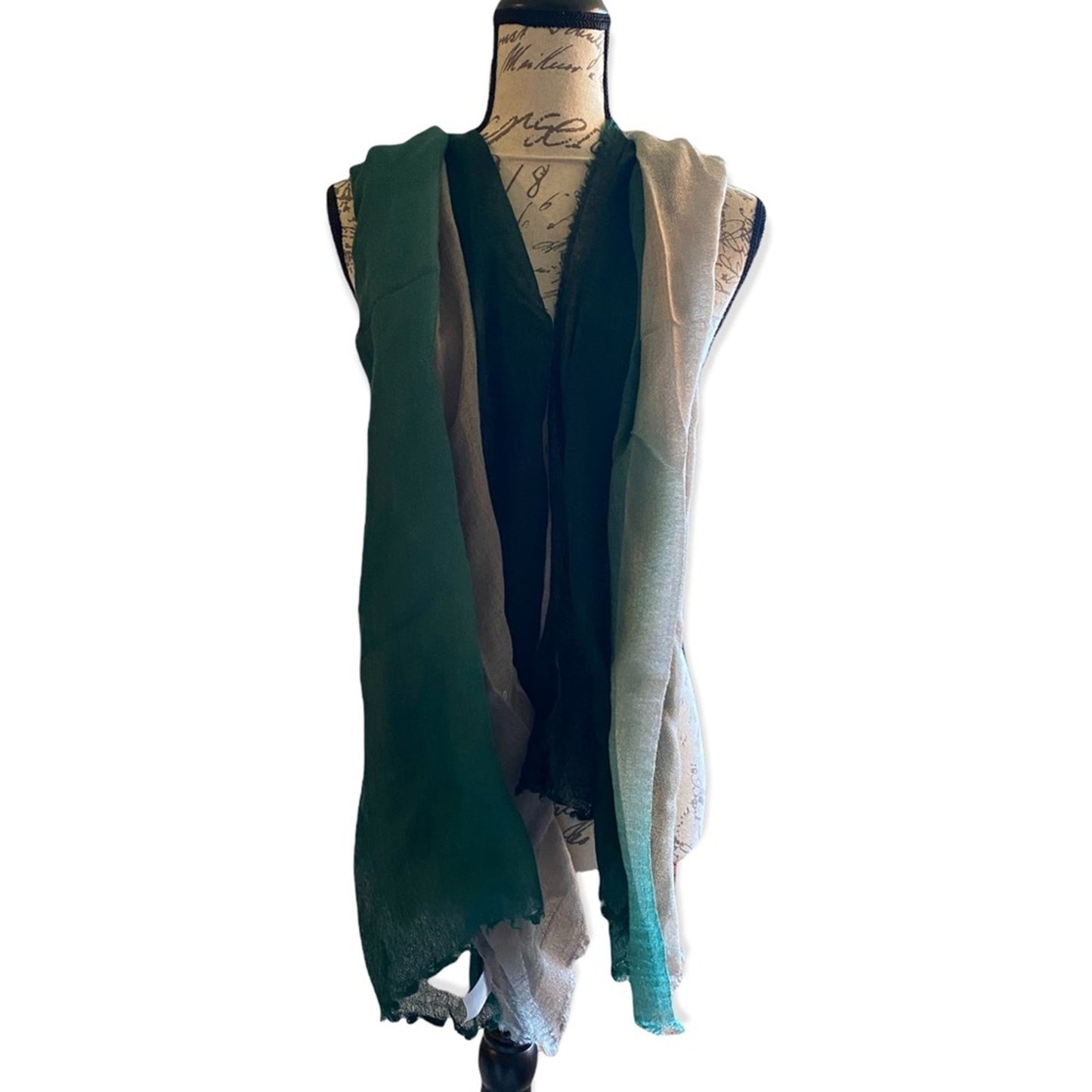 A ombre colored scarf draped over a dress form mannequin. 