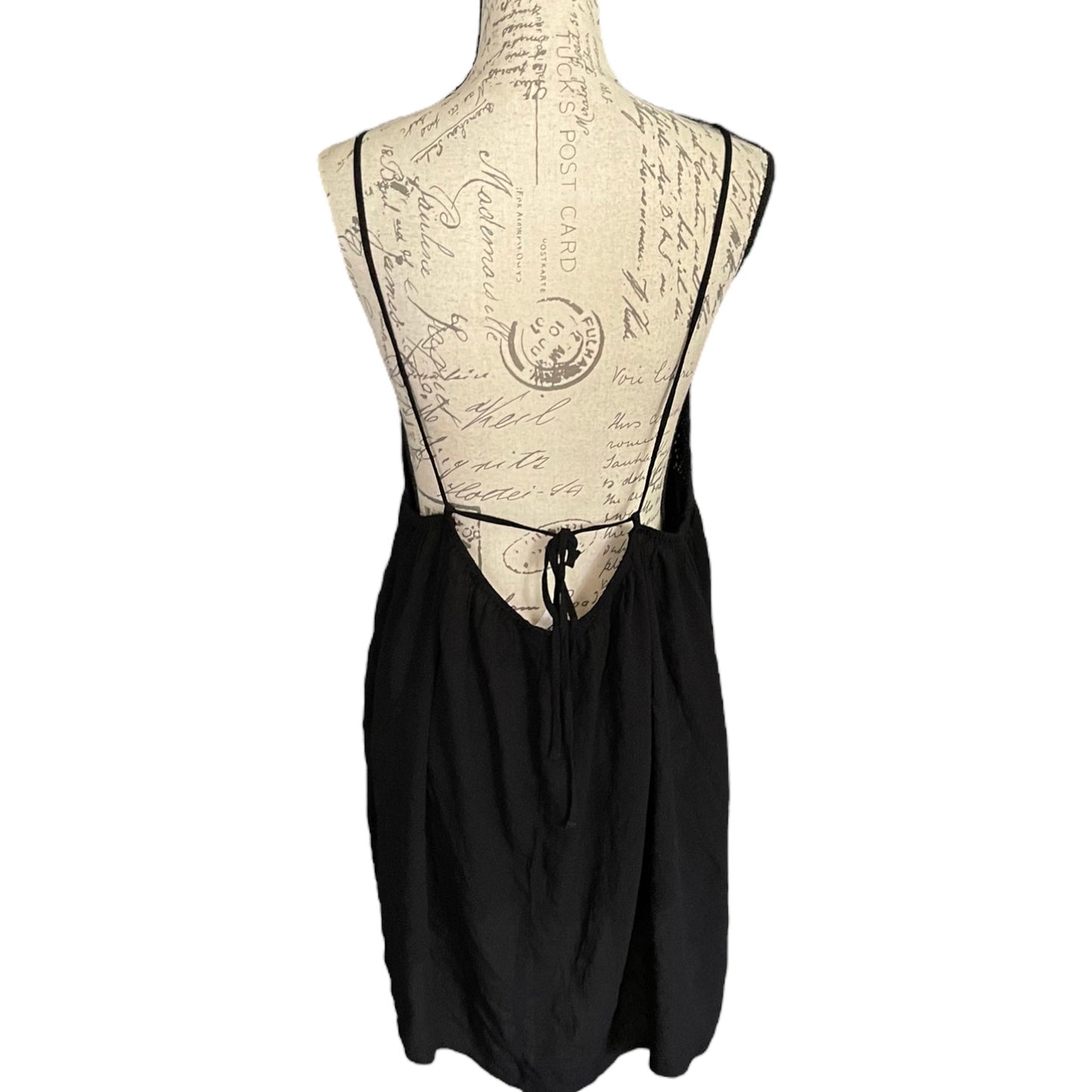 Black cover up back on a mannequin with an intricate back design against a white background