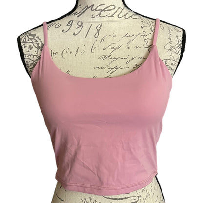 A pink spaghetti-strap sports bra displayed on a vintage-style paper-covered dress form mannequin against a white background.
