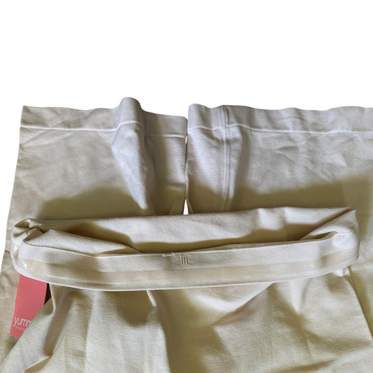 Beige shapewear shorts lining with a pink tag on a white background