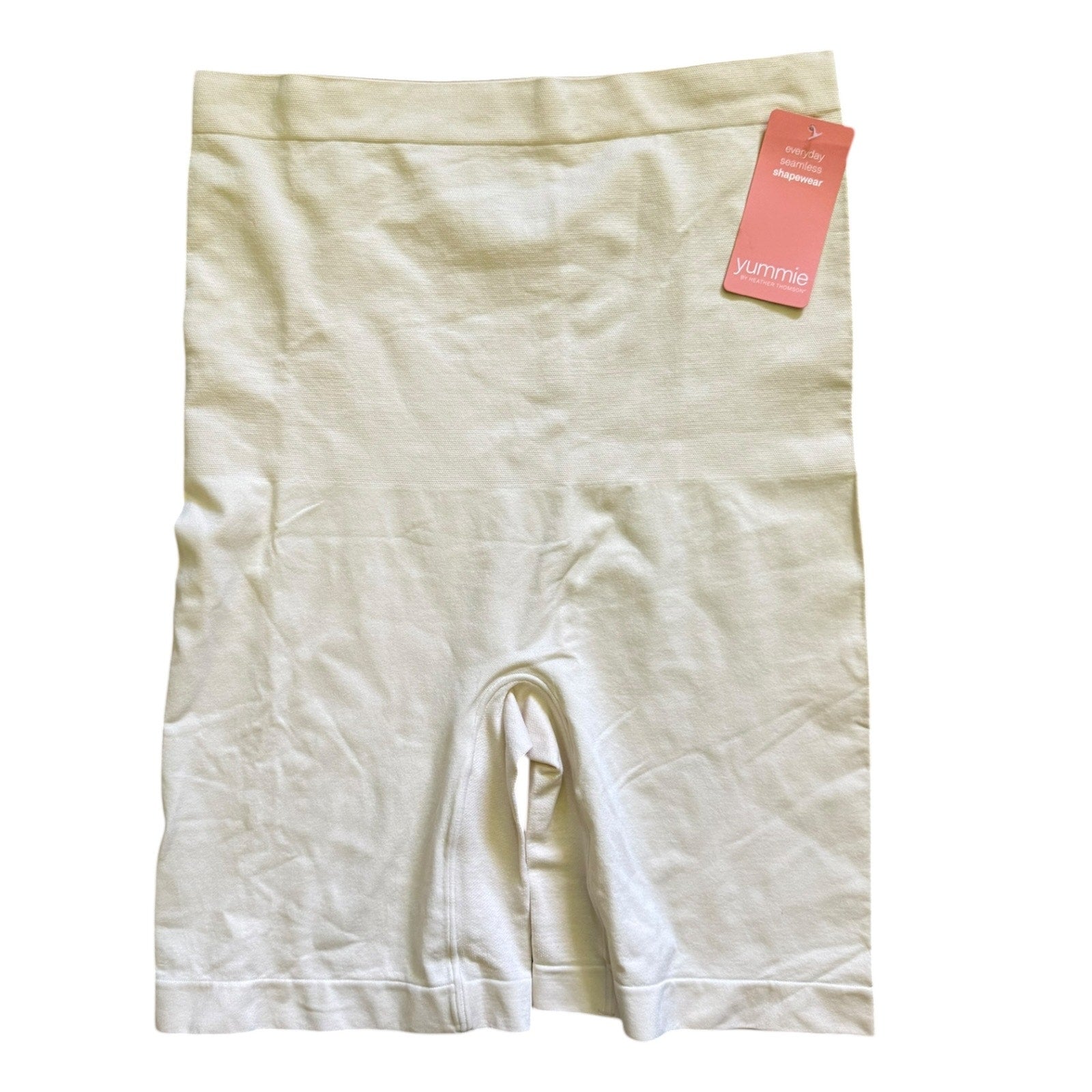 Beige shapewear shorts with a pink tag on a white background