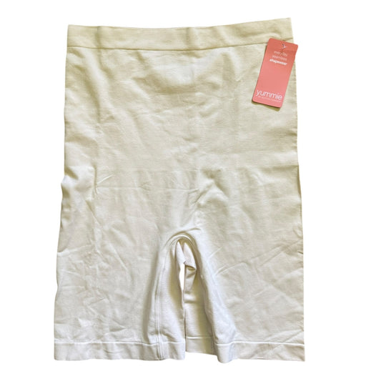 Beige shapewear shorts with a pink tag on a white background