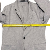 Gray blazer with a measuring tape draped over it on a white background