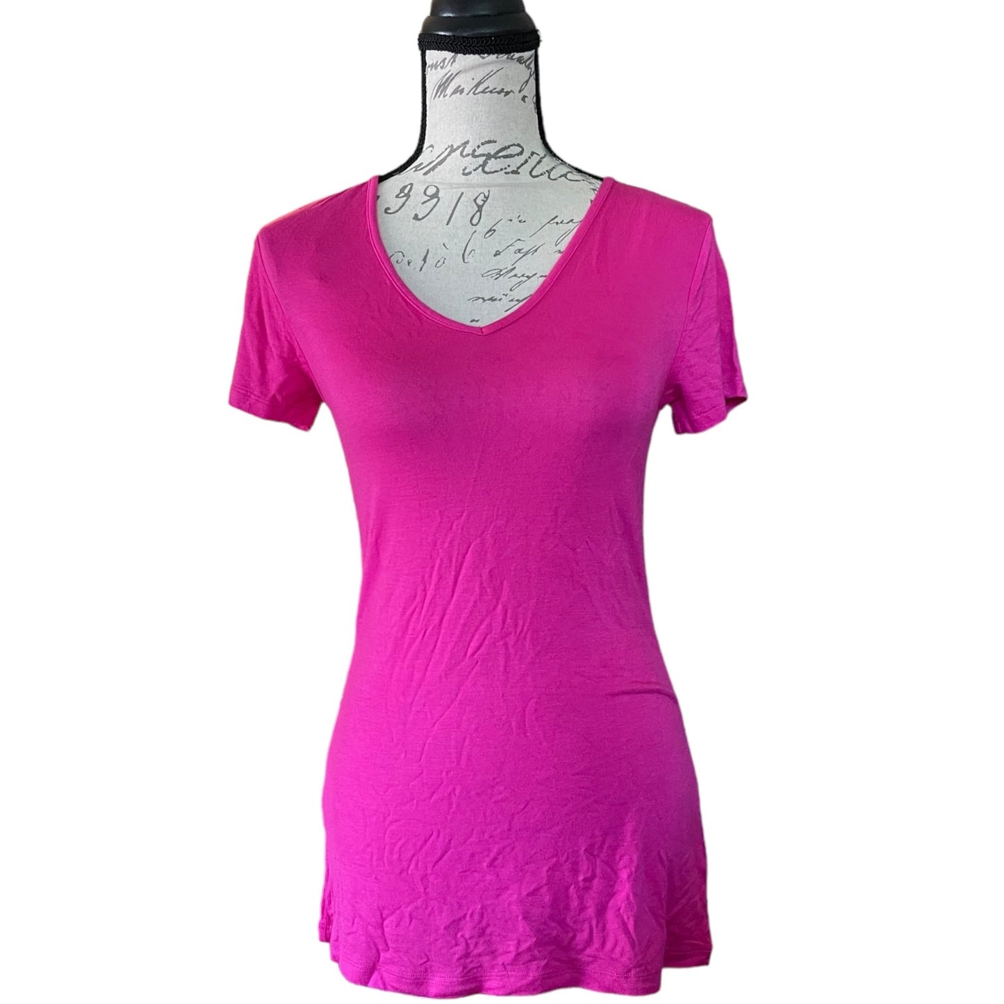 A bright pink short-sleeve V-neck t-shirt displayed on a dress form mannequin against a plain white background.