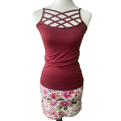 Red tank top with criss-cross design on a mannequin with floral skirt.