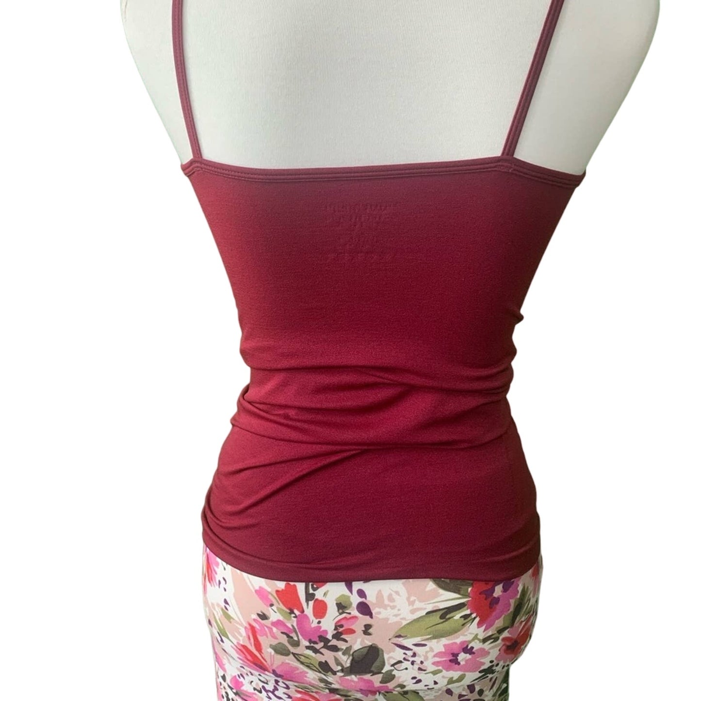 Red tank top on a mannequin with a floral skirt underneath on a white background