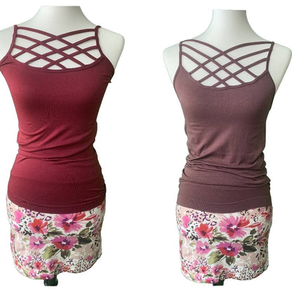 Two tank tops with criss-cross design on mannequins with floral skirts