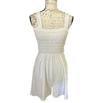 Front of off white romper on a mannequin with lace details against a white background