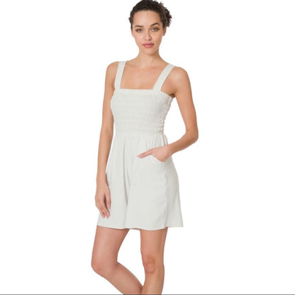 Woman wearing a off white romper on a white background